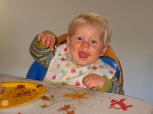 toddler having eaten and enjoyed a cake