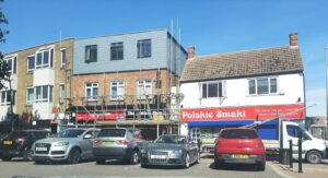 Scaffold platforms in front of a show with customer cars parked in front