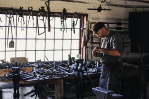 Worker in a cluttered workshop full of tools