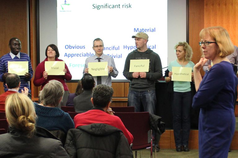 HS managers lined up holding cards with probability terms on